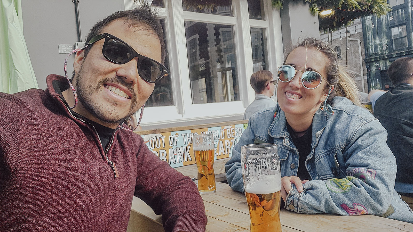 Hugo y Celia sonriendo juntos en la terraza de un bar