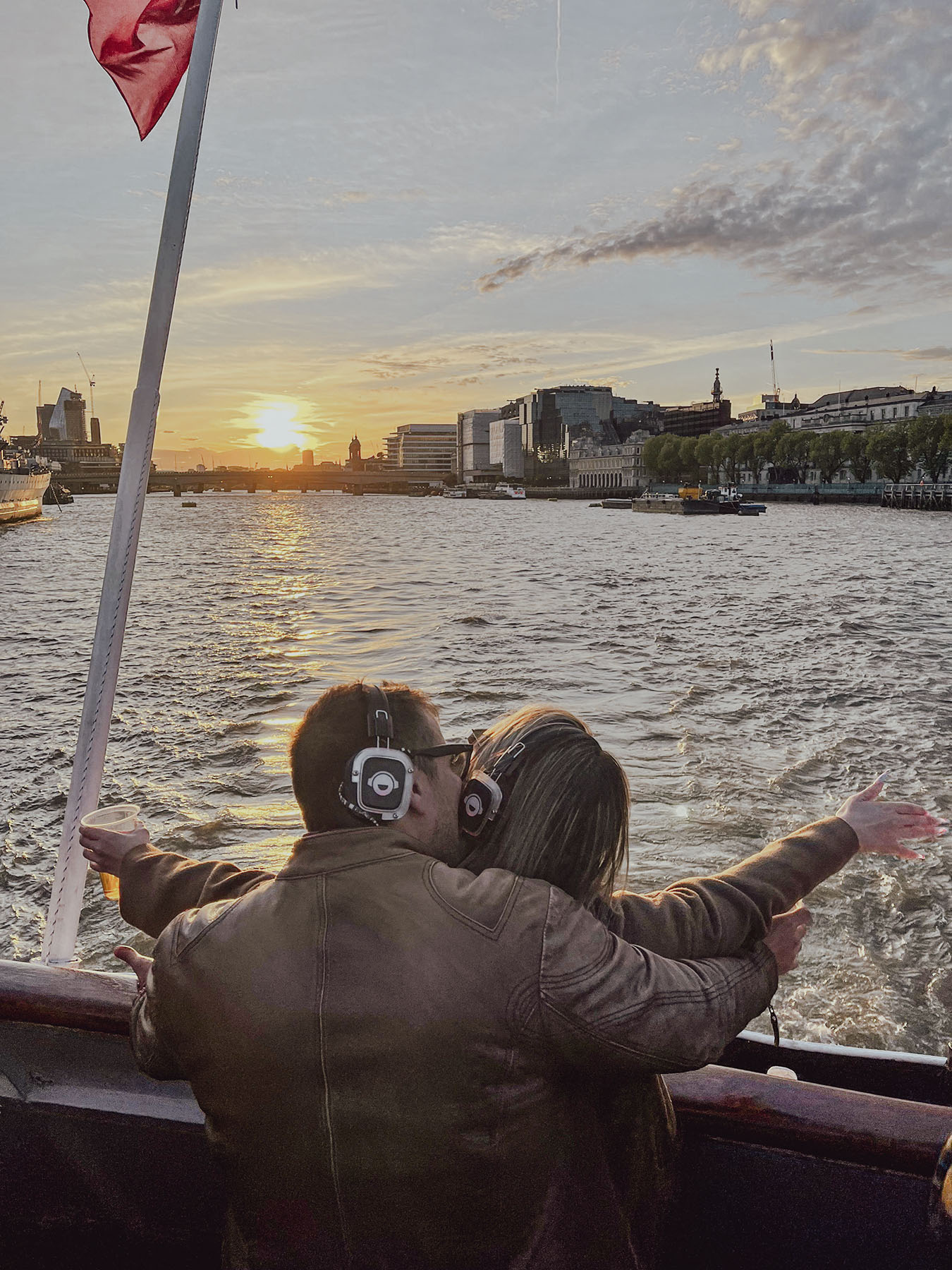 Hugo y Celia abrazándose al atardecer durante un paseo en barco por Londres